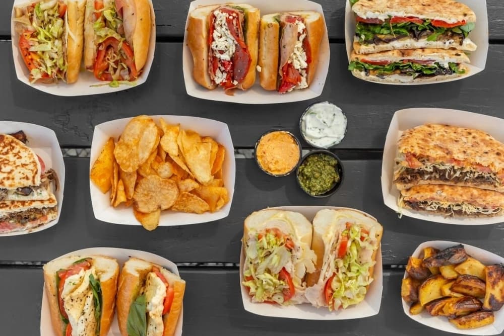 A table is filled with sandwiches and sides.