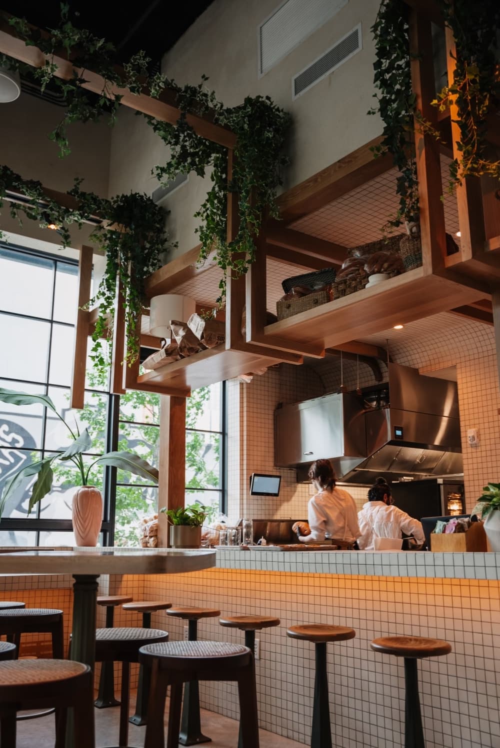 The tall ceilings are showcased with plates wrapping around the beams while chefs cook in the background.