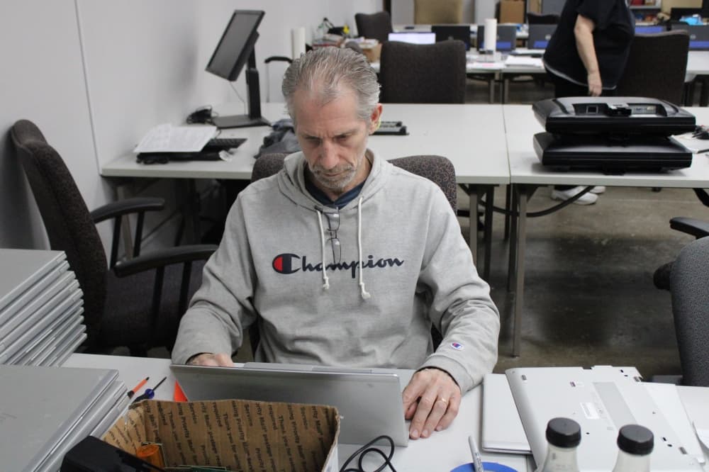 a volunteer installs assistive software on a computer. 