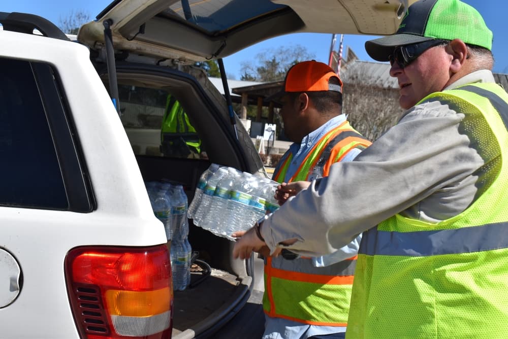 People load water into a car