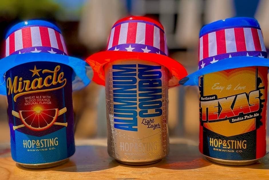 Three cans of beer with American themed hats
