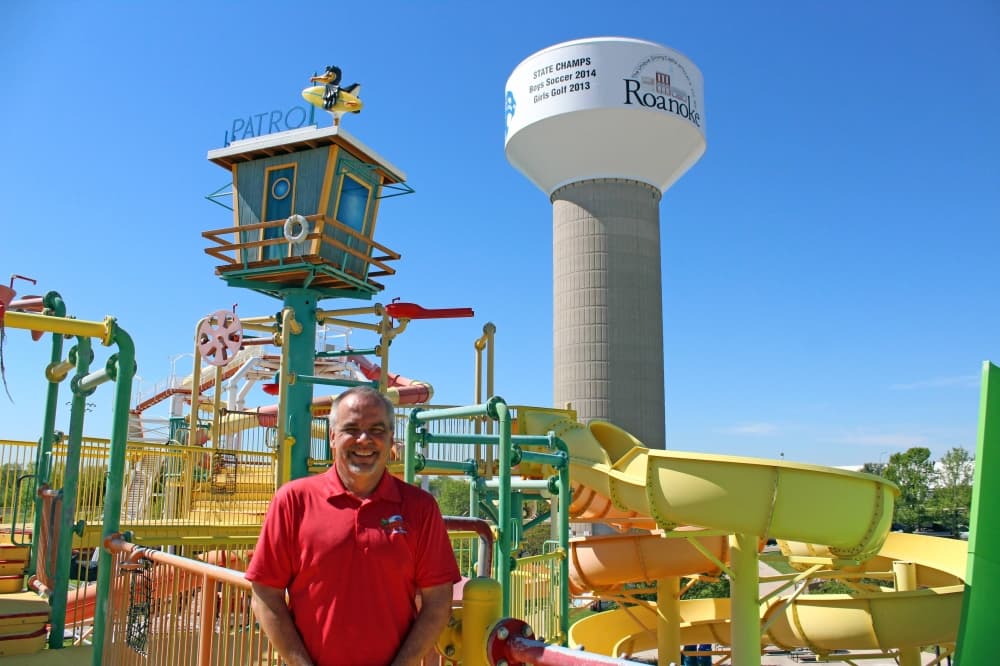 Male standing in front of a water park playground.