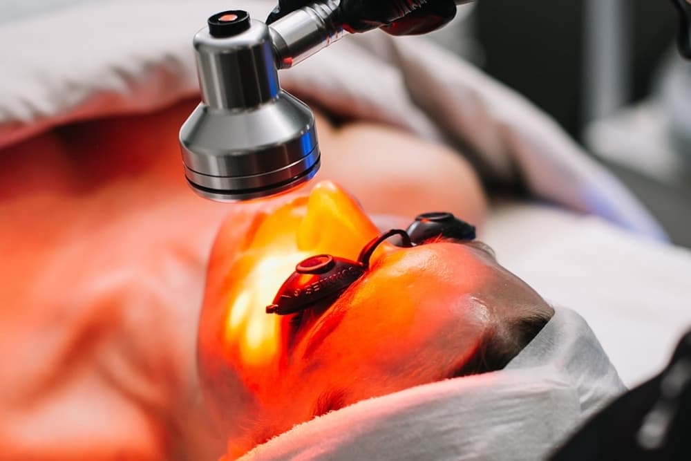 A person receives a light treatment on their face.
