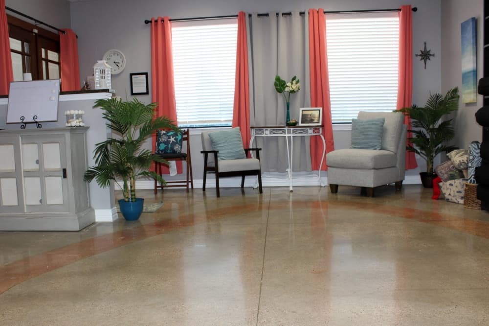 Room with two windows and salmon colored curtains. 