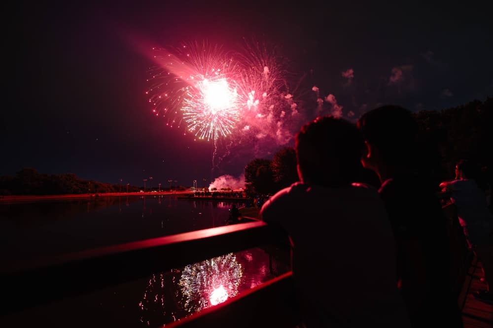 Silhouette of people watching red fireworks. 