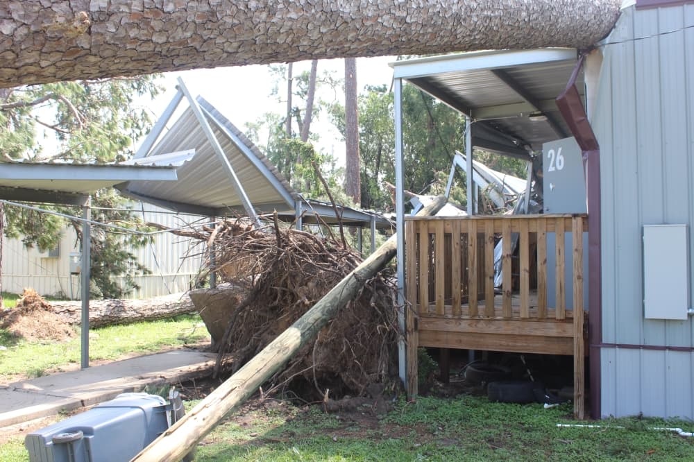 A utility pole knocked over and crashing through a building