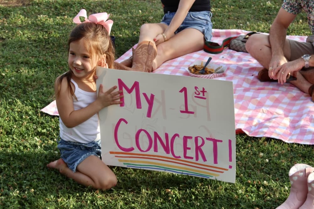 A little girl holds up a sign