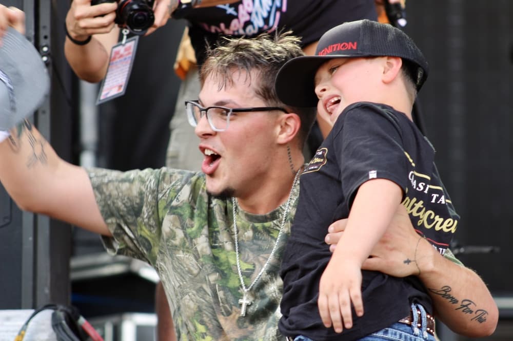 A man and a boy watch a concert