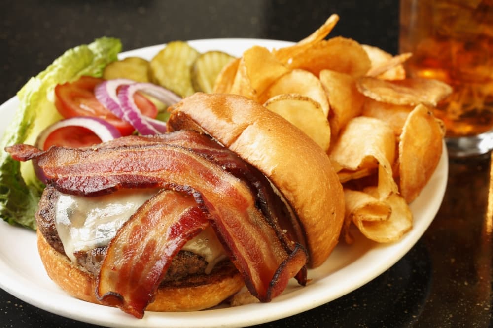 Burger with bacon and side of chips.