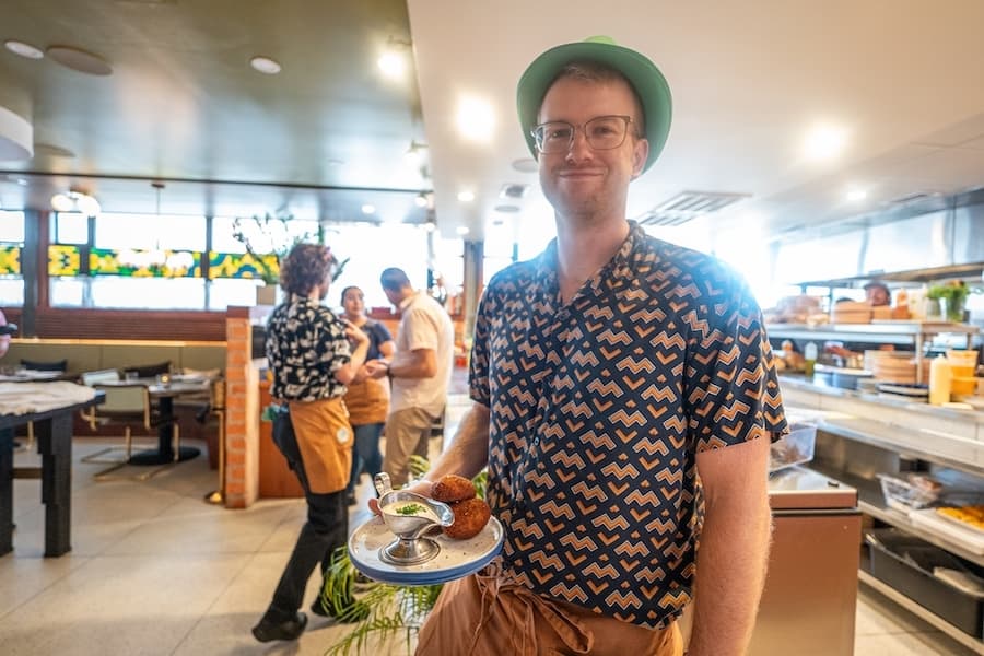 A person holding duck croquettes at Eau Tour. 