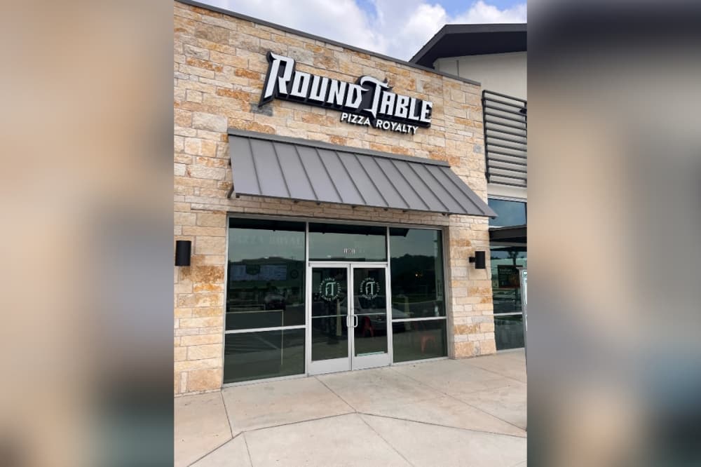 Image shows exterior of Round Table Pizza.