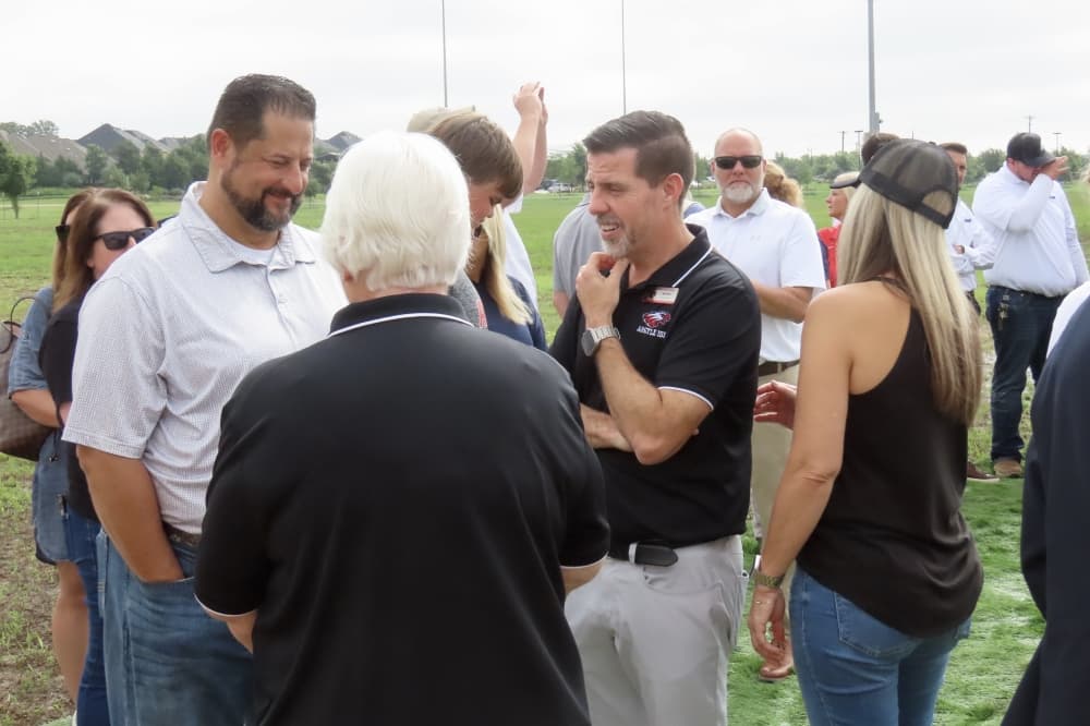 Teachers, students, school board trustees, district administrators, industry professionals and community members gathered in a rain-soak field to celebrate the stadium's groundbreaking June 5. (Jonathan Perriello/ Community Impact)