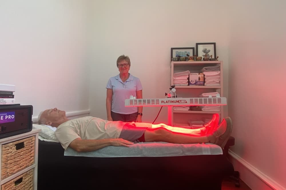 Practitioner Jackie Messer demonstrated red light therapy on a patient. (Parks Kugle/Community Impact)