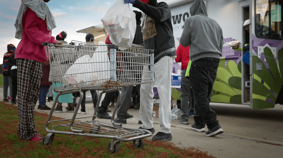 People putting food items in grocery cart