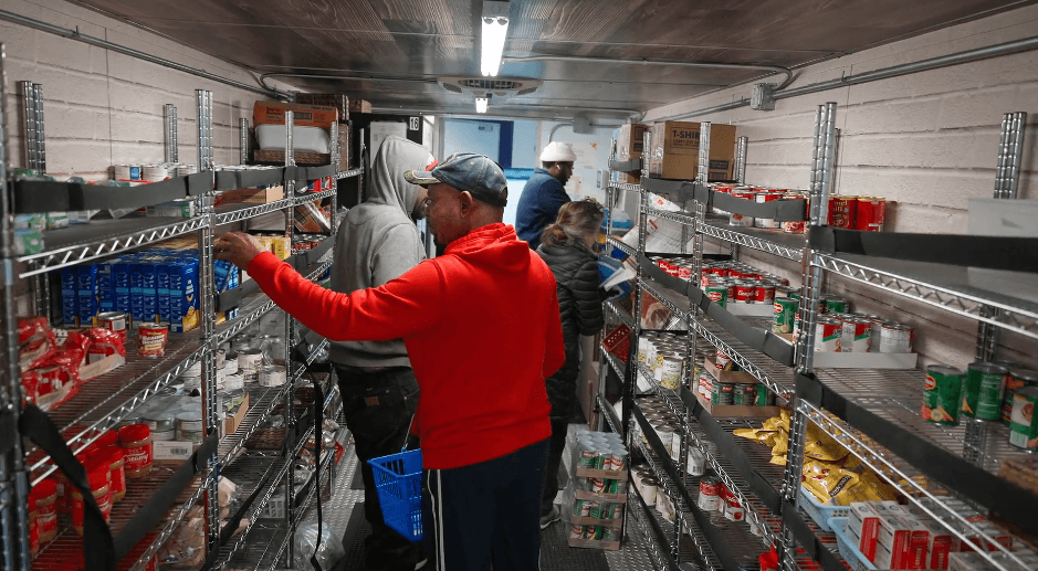 People picking up food items from truck.