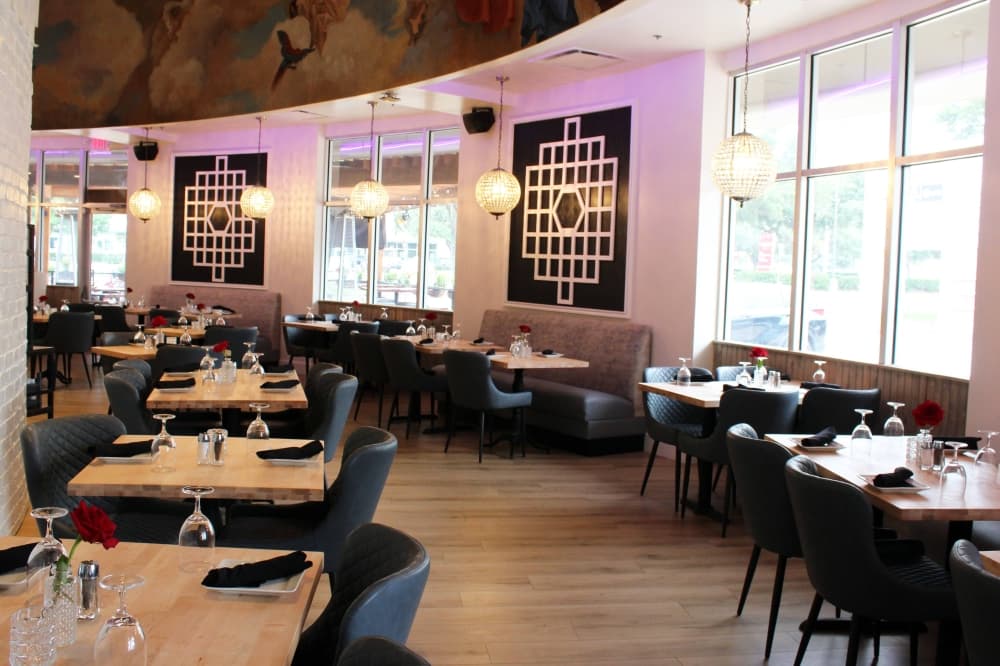 Interior of a restaurant with a curved wall of windows. 
