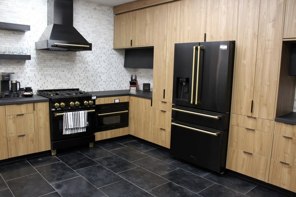 Kitchen showroom featuring black and light brown color scheme. 