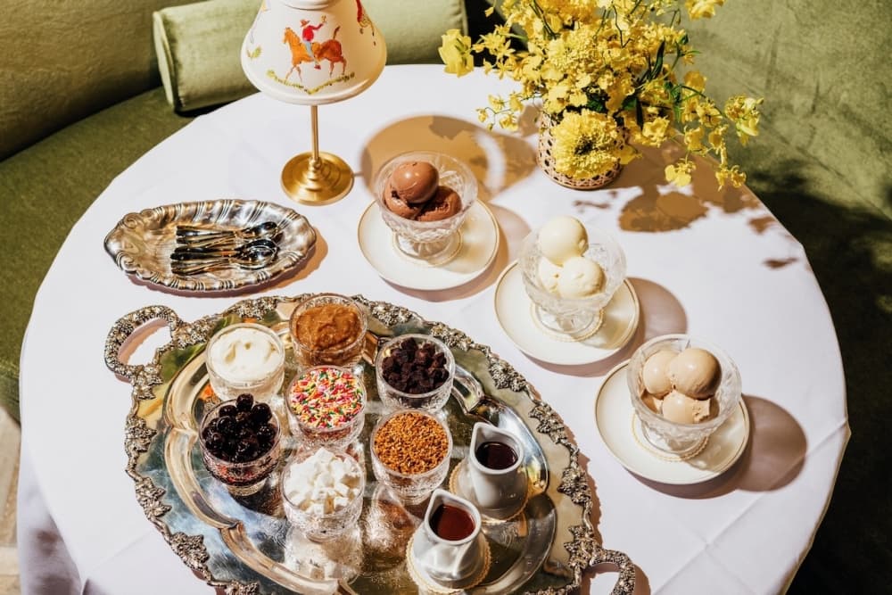 A photo of ice cream and toppings served on a silver platter.