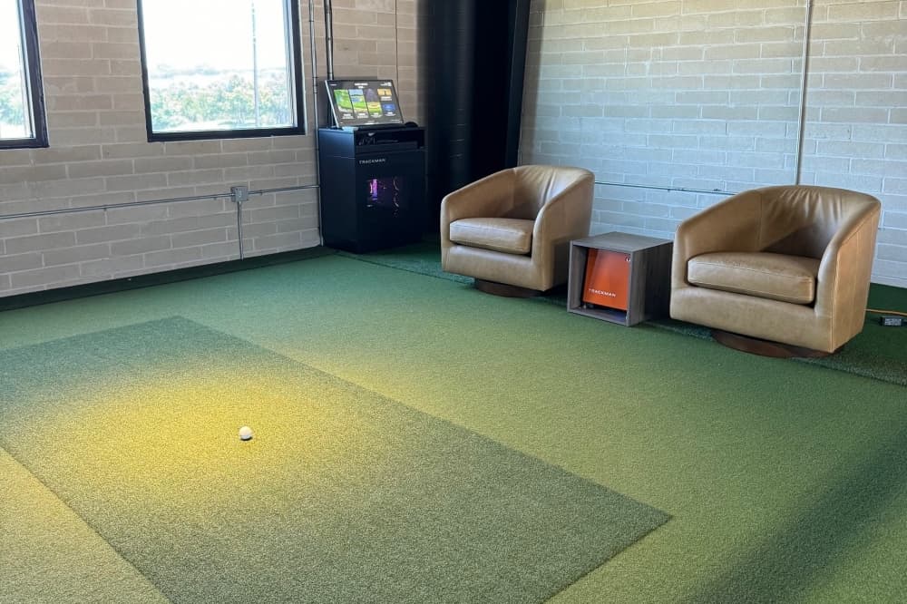 Golf bay with chairs and putting green