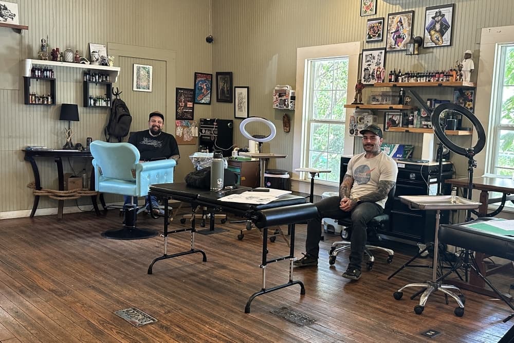 The two owners are shown inside the shop.