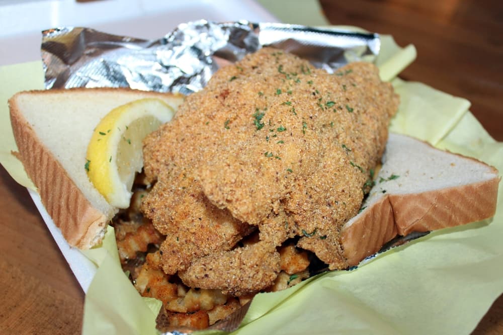 Container of fried catfish and bread. 