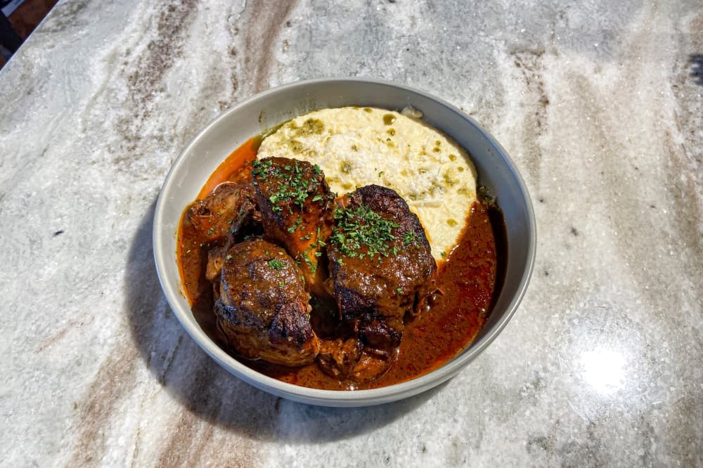 The Osso Buco, which has a variable market price, is made up of braised veal shank, polenta and veal demi.
