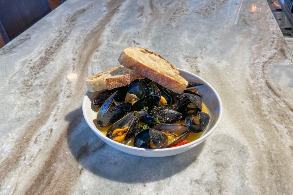 P.E.I. Mussels ($16) are served in a white wine garlic sauce with grilled ciabatta bread. (Parks Kugle/ Community Impact)