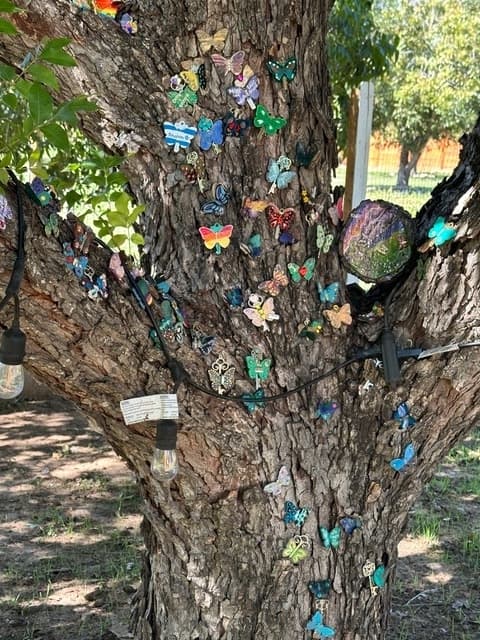 A tree is filled with butterfly art.