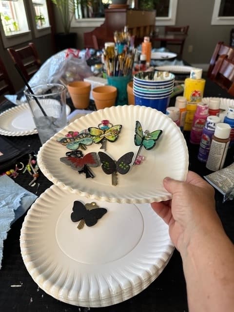 Jana Lynch holds up some of the butterfly art on a paper plate at the bar.