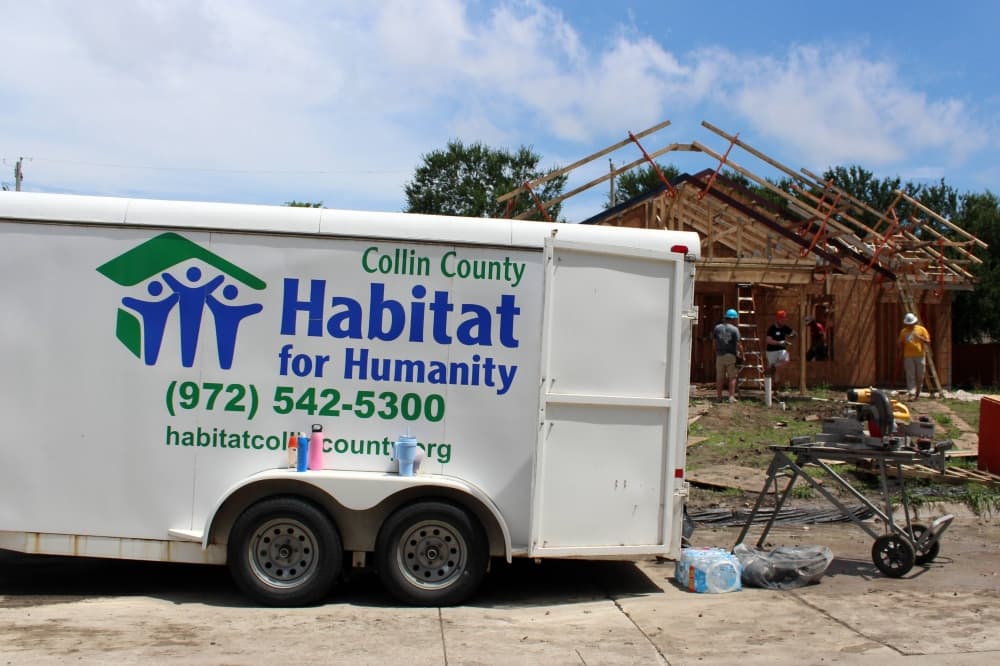 Trailer with Habitat for Humanity Collin County signage parked in front of a constructions site. 