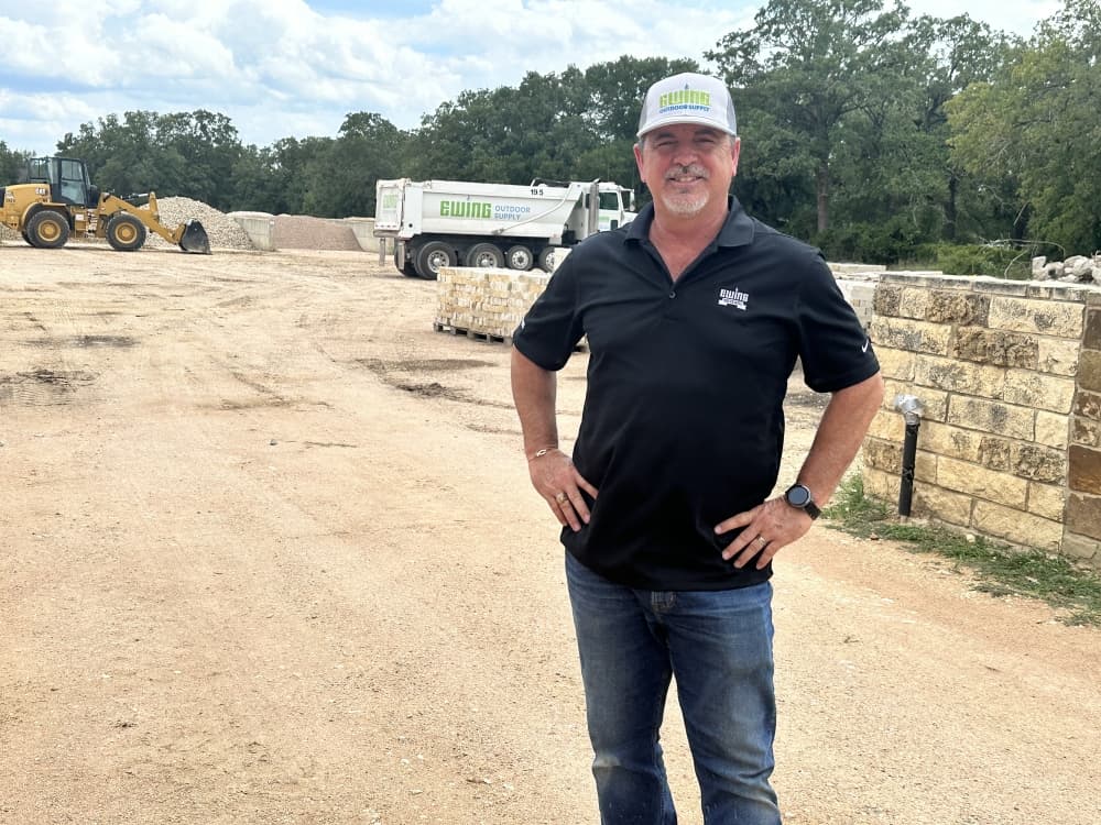 The manager poses for a photo in front of the rock yard.