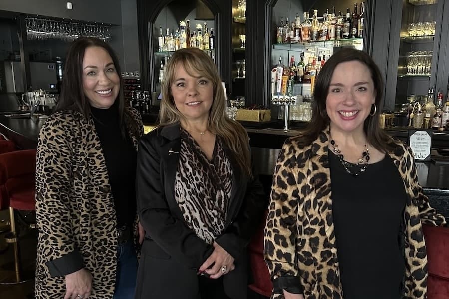Picture of three women standing in a restaurant.