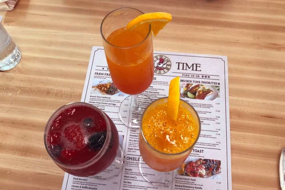 Three drinks on top of a menu. 