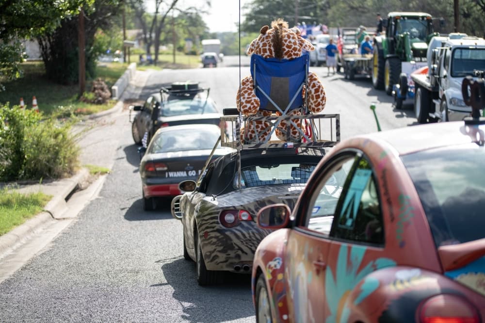 A line of cars participating in the event are shown from a previous year.