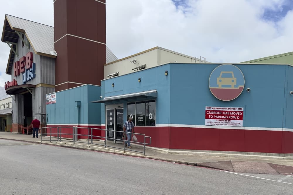 An exterior look at the store, with a sign directing shoppers to the temporary curbside area.
