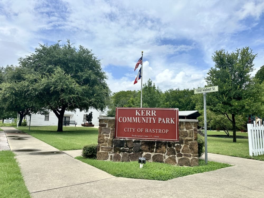 The Kerr Community Park sign is shown in the foreground, with the sculpture in the background to the left.