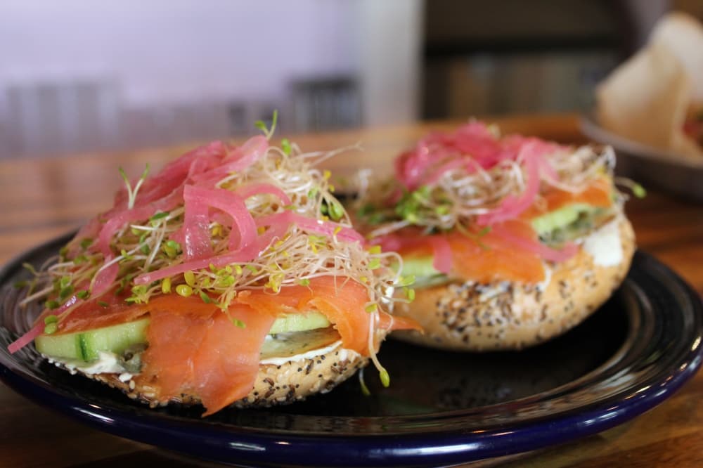 The lox bagel ($12) is smoked salmon, herbed cream cheese, cucumber, sprouts, capers and pickled onion on a bagel of choice. (Sarah Hernandez/Community Impact)