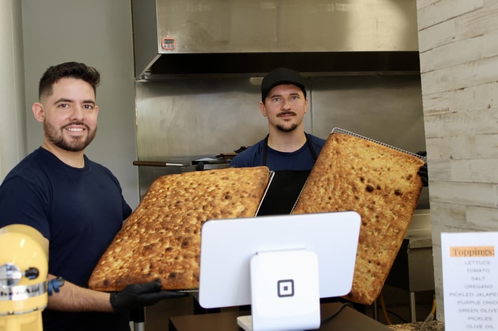 owners behind counter with bread