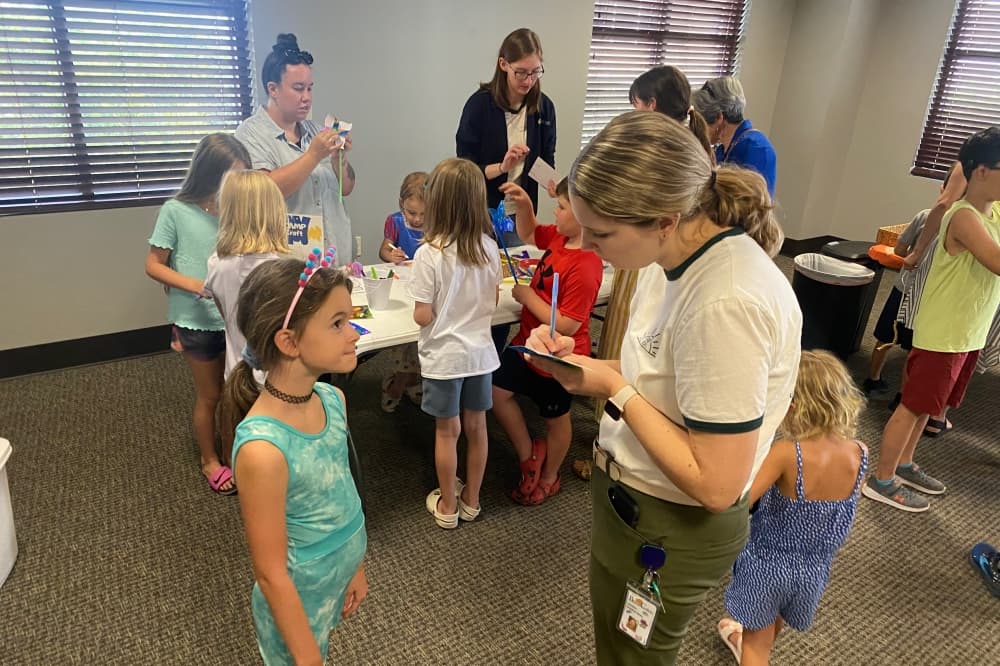 Assistant Library Director Gretchen Hardin helped a camper prepare her old-school postcard to mail home.(Courtesy Bee Cave Public Library)