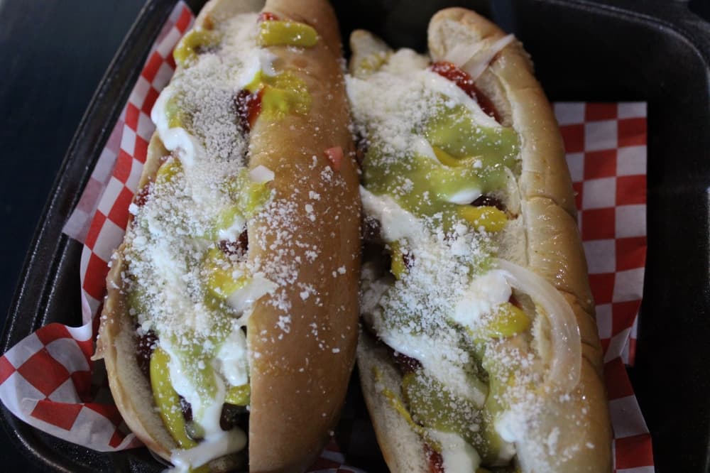 The Sonoran hotdog ($5.99 each) features a bacon wrapped hot dog with mustard, ketchup, grilled onions, beans, tomato, cotija cheese, guacamole and cream of mayonnaise. (Dustin Butler/Community Impact)