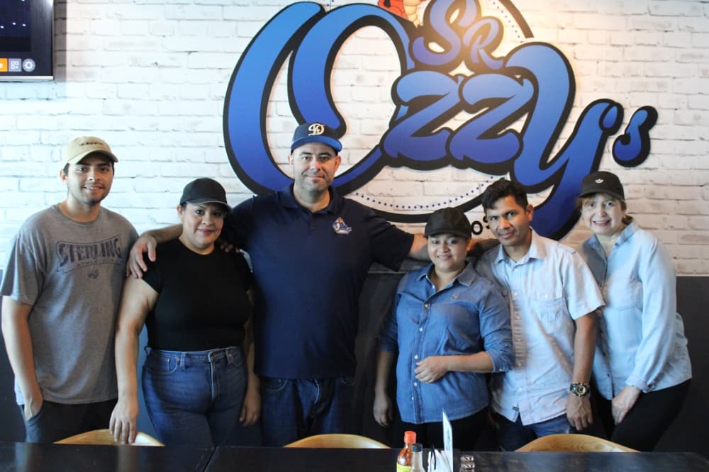 Sr. Ozzy's Tacos Y Mariscos owner Armando Duran with his staff and his wife, Myra, and his son, Armando.