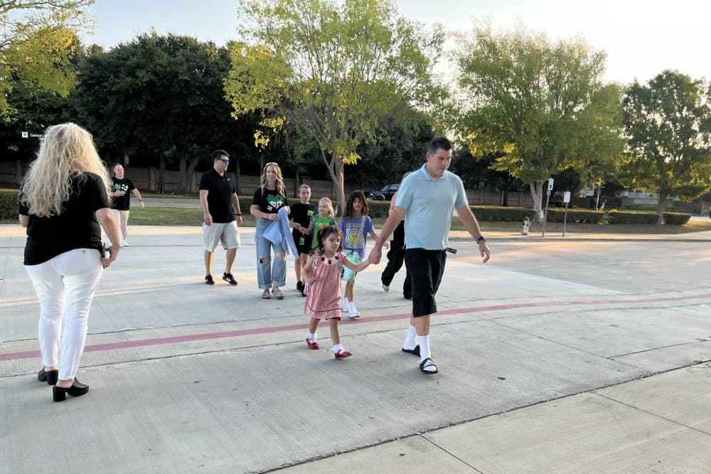 Students and parents walking in parking lot toward school