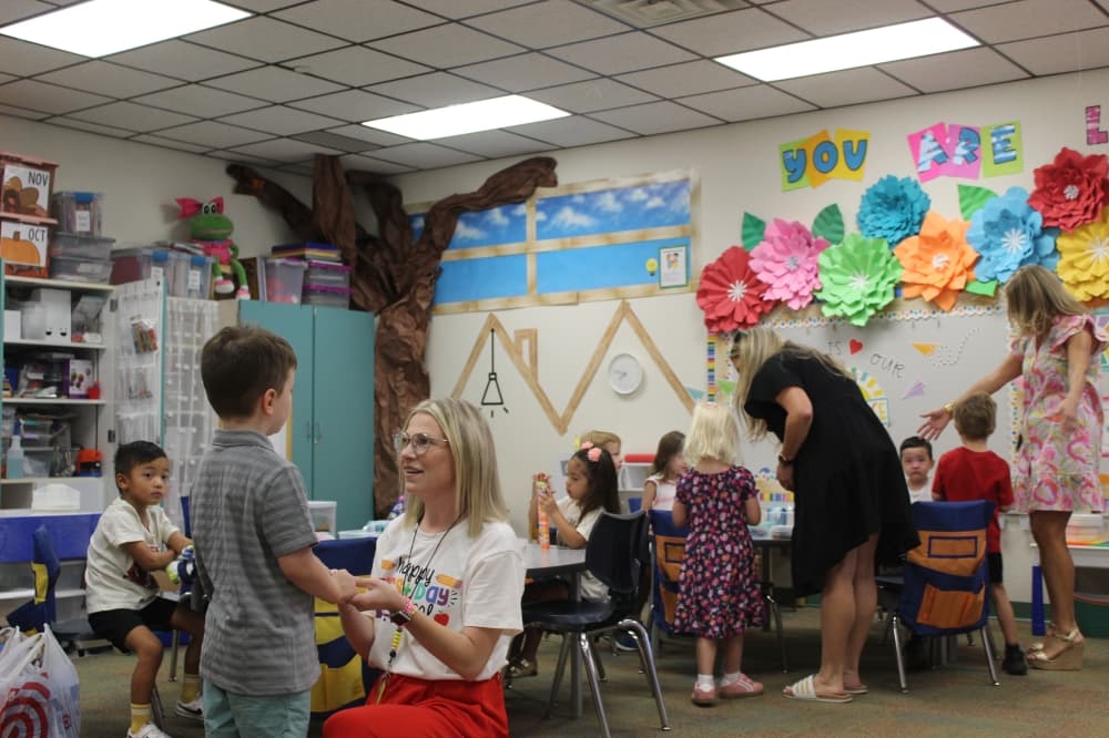 Kindergarten Teacher Bailey Webster speaks with a student during the first day of school Aug. 14.