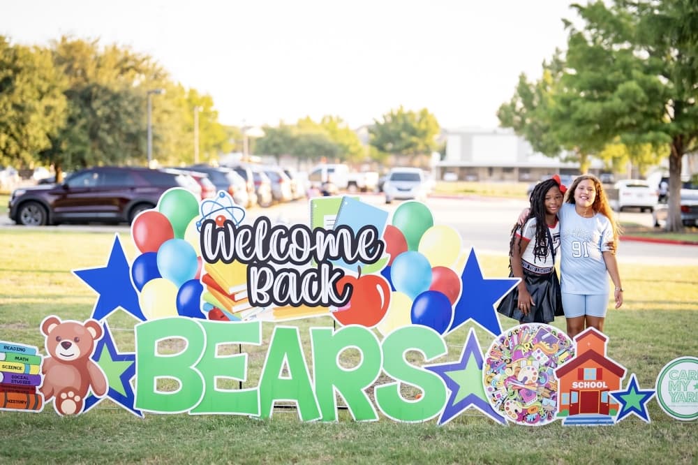 Students pose next to a welcome sign at Rockbrook Elementary Aug. 13. (Courtesy Lewisville ISD)