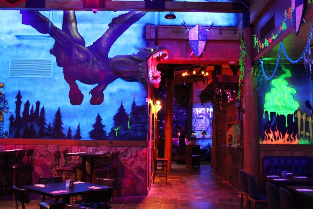 Dark room with glow in the dark spooky murals and a 3D dragon element. 