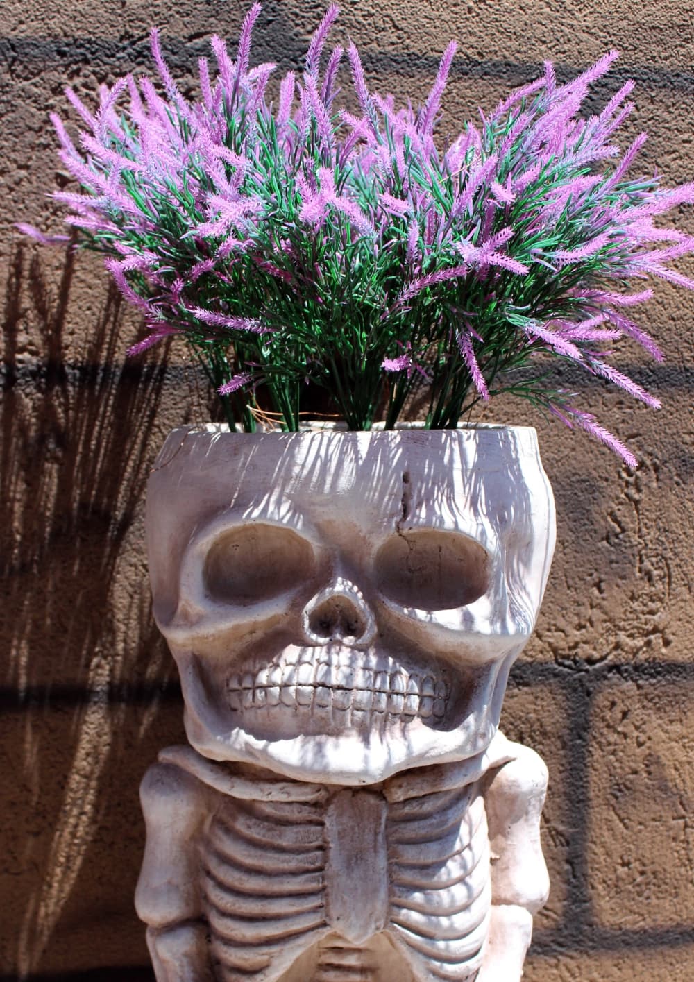 Skeleton planter with purple flowers. 