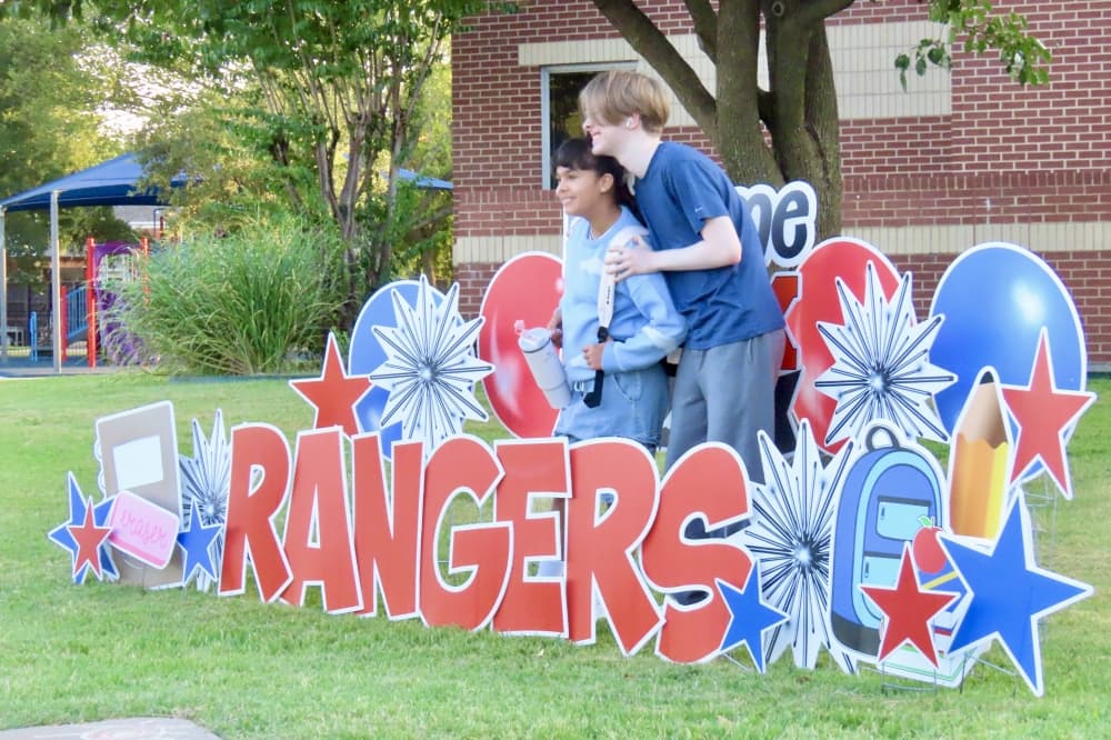 Students pose behind a welcome sign at Wilson Elementary Aug. 14. (Jonathan Perriello/Community Impact)