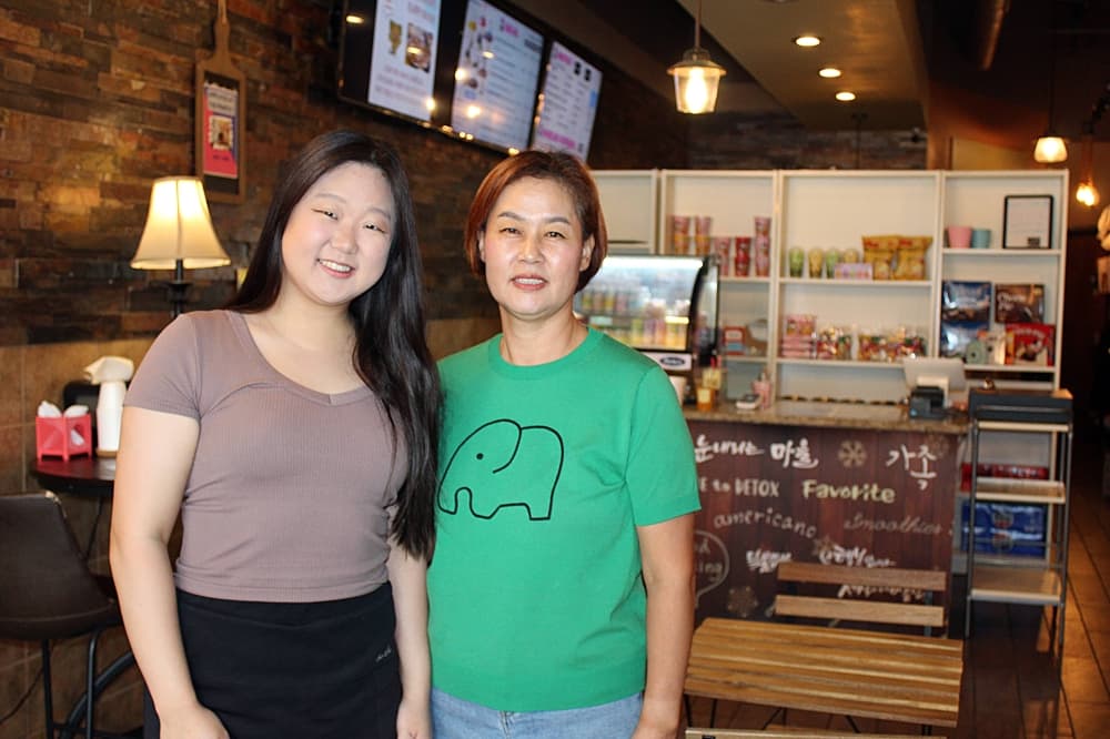 Two females standing in a restaurant. 
