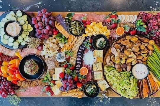 A charcuterie display with fruits, cheeses and meats. 