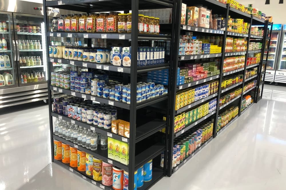 Canned and boxed food items on shelves in a store. 